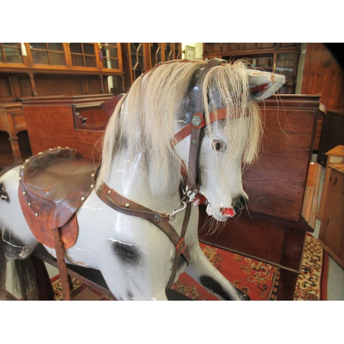 9 - An early 20thC painted dappled grey nursery rocking horse with a studded hide saddle, tail and mane,... 