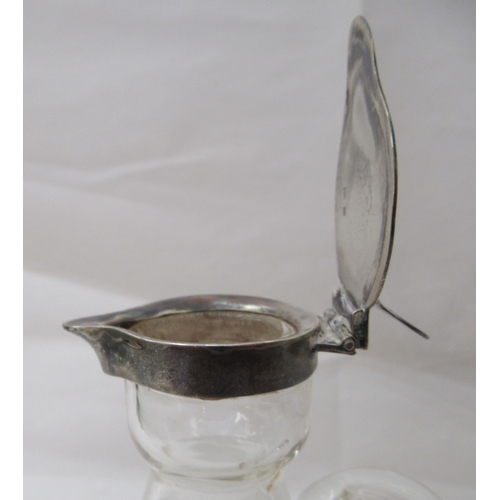 54 - An Edwardian glass whisky tot of conical form with an applied silver collar and a hinged cap  Birmin... 