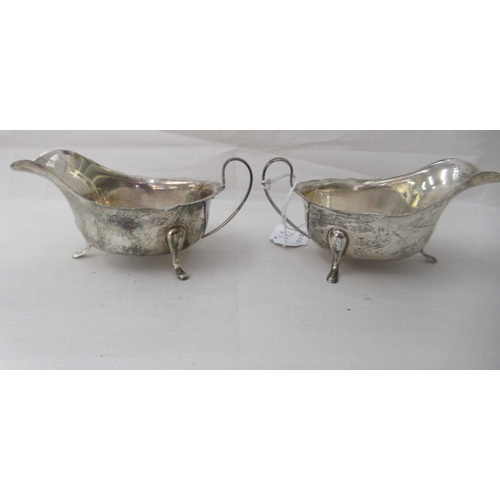 60 - A pair of silver sauce boats, each with a wavy lip, on pad feet  Sheffield 1940