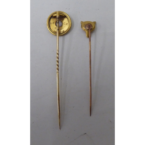19 - Two yellow metal stickpins, viz. one a foxes head, the other embellished in blue enamel, set with a ... 