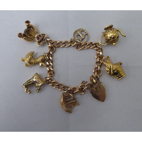 34 - A 9ct gold curb link bracelet with seven 9ct gold and yellow metal charms 