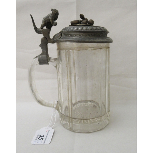 35 - An early 20thC Bavarian glass tankard with a pewter lid, fashioned as a man bowling skittles