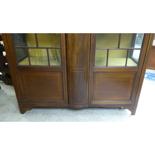 16 - An Edwardian string inlaid mahogany china cabinet with a pair of glazed doors, enclosing three fixed... 