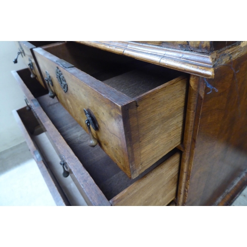 27 - A George II crossbanded walnut bureau, the fall-flap over two short/two long drawers, on a plinth an... 