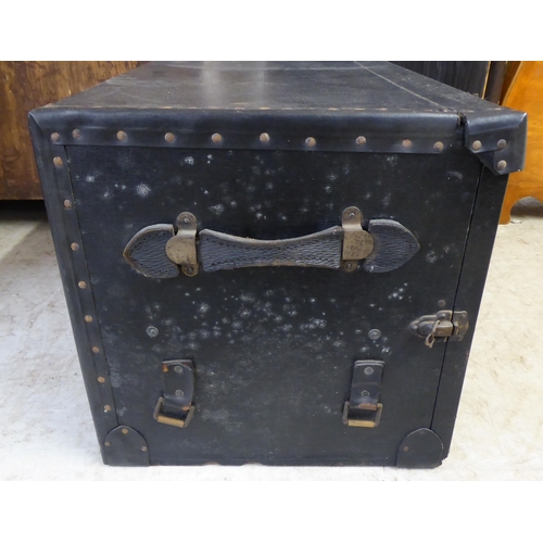 3 - An early/mid 20thC stud cased bound cabin trunk, the hinged lid and fall front containing two suitca... 