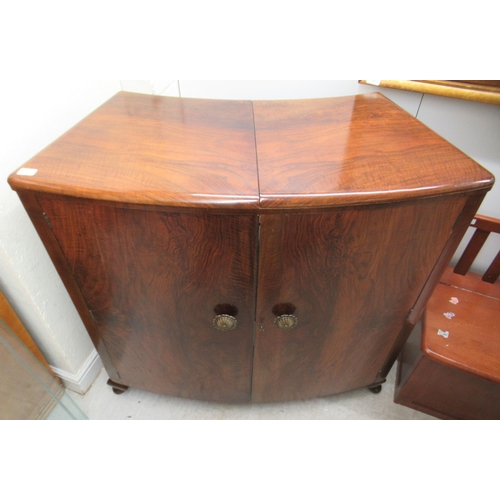 45 - An Art Deco inspired walnut finished bow front, freestanding bar with extending, hinged flaps, openi... 