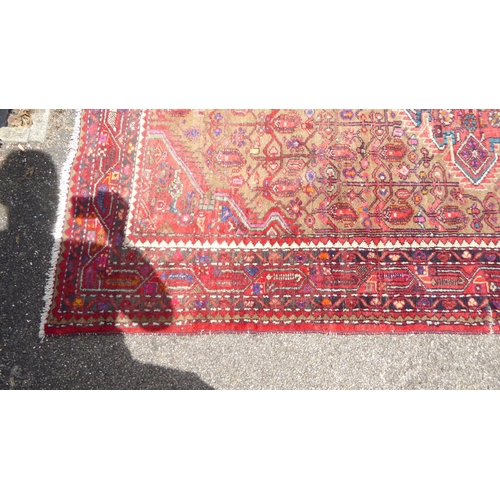 47 - A Persian rug, decorated with repeating stylised designs, on a multi-coloured ground  59