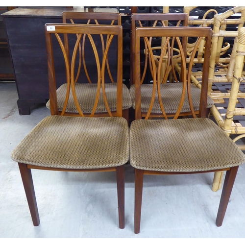 52 - A set of four G-Plan teak framed dining chairs, the fabric covered seats raised on square legs