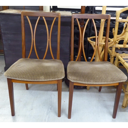 52 - A set of four G-Plan teak framed dining chairs, the fabric covered seats raised on square legs