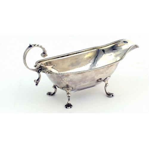 46 - A small unusual English silver Cream Jug, with gadroon edge, shell decorated handle on four pad feet... 