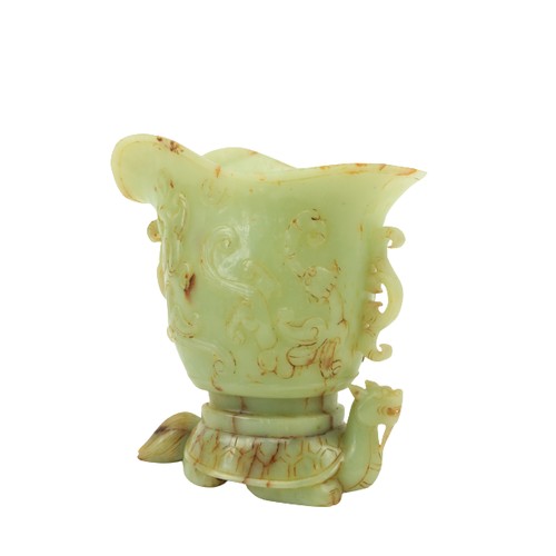 29 - A fine carved Chinese jade Libation Cup, carved in relief with scrolls under a double spout and two ... 