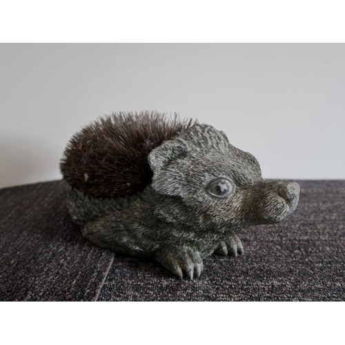47 - An early 20th century painted plaster model of a hedgehog, 34 cms long, 17 cms high.