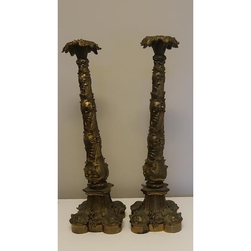50 - A pair of 19th century cast metal and vine decorated table candlesticks on shaped base, 52 cms high.