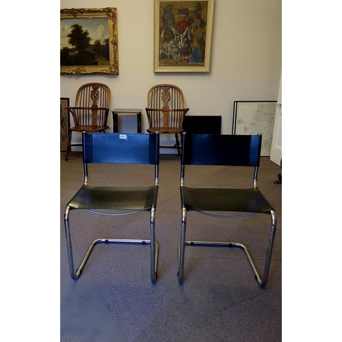 57 - A pair of mid century black leather and chrome cantilever chairs, 82 cms high.