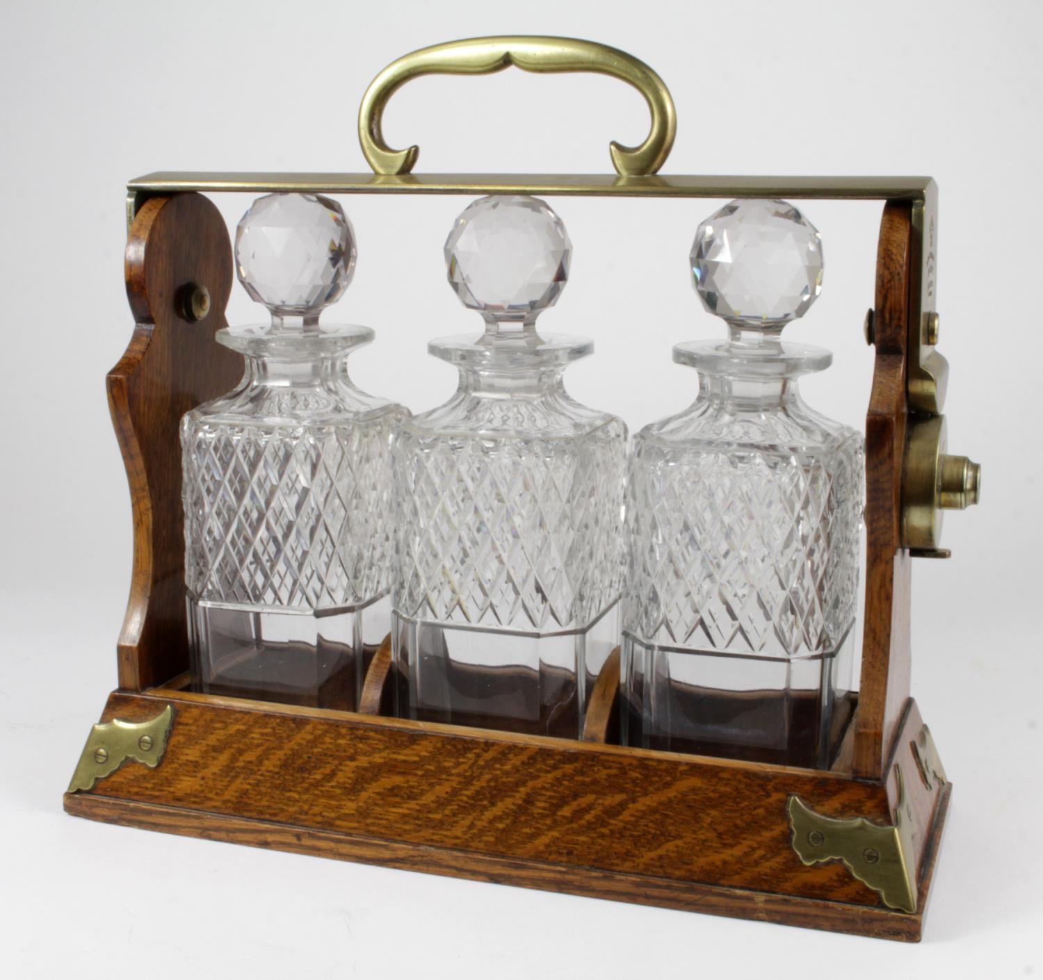 Tantalus. A walnut three decanter tantalus by Betjemann (no. 1200 ...