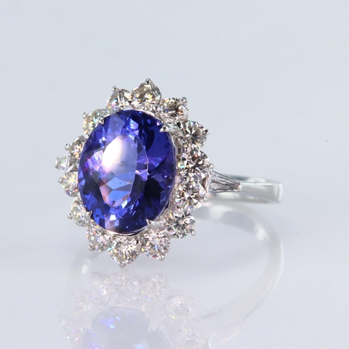 51 - 18ct white gold ring featuring a central oval tanzanite weighing 3.92ct, surrounded by fourteen roun... 