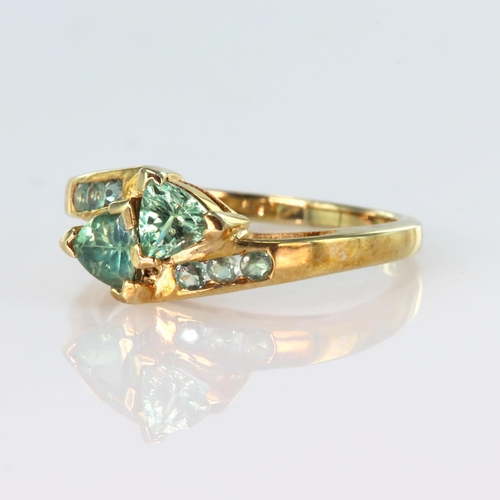 52 - 9ct yellow gold crossover style ring set with two trilliant cut alexandrite, with six further round ... 