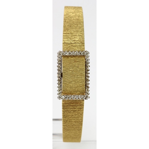 579 - Ladies 18ct Longines wristwatch (hallmarked 1978). On an 18ct integral bracelet with diamond bezel o... 