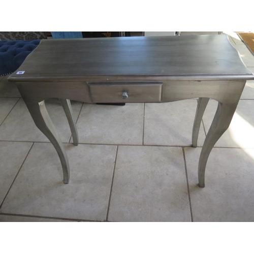 44 - A silver painted side table with a drawer, 86 cm tall x 100 cm x 40 cm