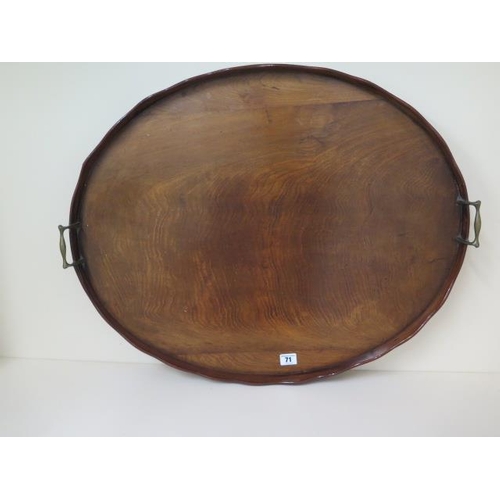 71 - An early 1900s mahogany oval twin handle tray with a shaped rim, 71cm x 58cm