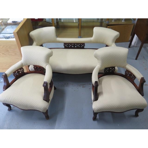 55 - An Edwardian mahogany and upholstered salon suite comprising sofa and two armchairs, with cream foli... 