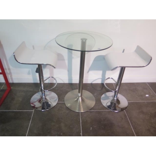 43 - A glass top bar table, 91cm tall x 60cm diameter with two white laminated gas lift stools, some usag... 