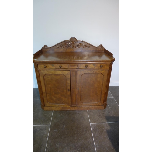 79 - A 19th century mahogany side cupboard / chiffonier with a carved upstand above two drawers and two c... 
