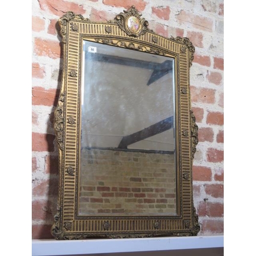 66 - A gilt wall mirror with porcelain plaque - some gesso losses and cracking to gesso but a decorative ... 