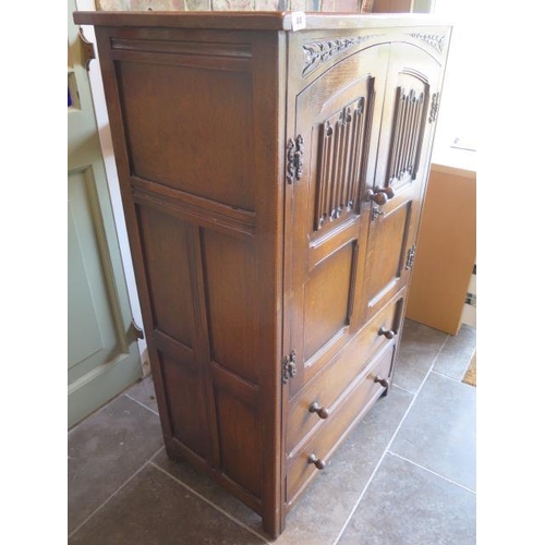 44 - An oak linen fold cupboard with two doors over two drawers having panelled sides - Height 123cm x 76... 