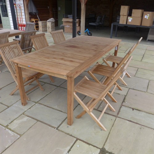 19 - A teak garden table and six folding chairs - in good condition - 220cm x 100cm