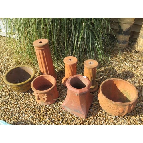 18 - A terracotta plant stand 61cm tall, a pair of smaller stands, two terracotta planters, a small chimn... 