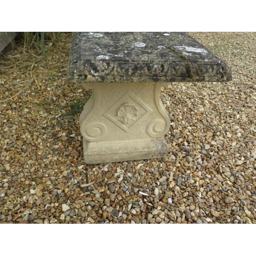 25 - A stone effect garden bench with a weather top on two supports, 50cm tall x 120cm x 42cm