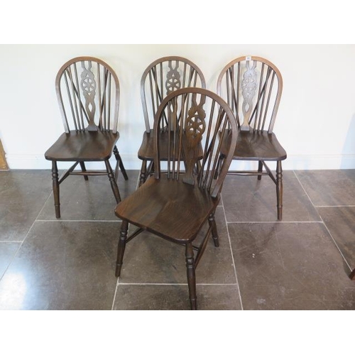 55 - A set of four early 20th century wheelback dining chairs in good polished condition