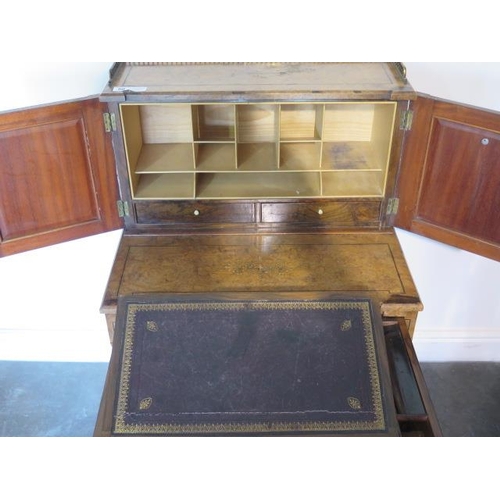 50 - A good Victorian walnut writing desk with a two door brass galleried top with fitted interior above ... 