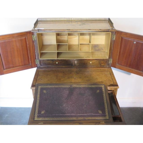 50 - A good Victorian walnut writing desk with a two door brass galleried top with fitted interior above ... 