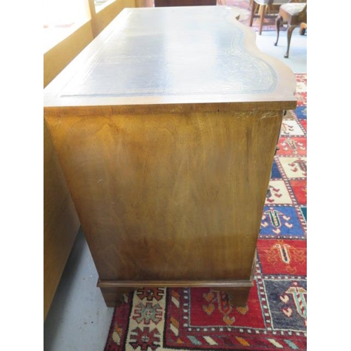 56 - A mahogany serpentine fronted nine drawer kneehole desk with a leather inset top, 75cm tall x 116cm ... 