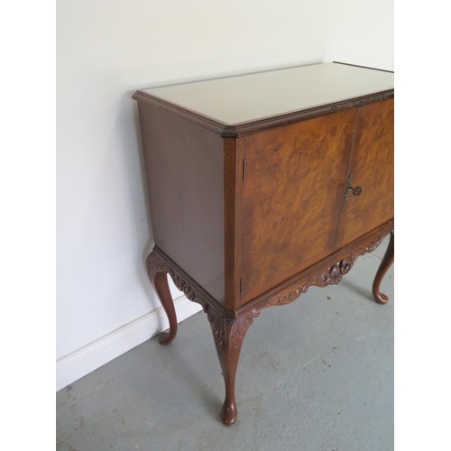 65 - A carved walnut two door cabinet on cabriole legs with a protective glass top, 98cm tall x 89cm x 47... 