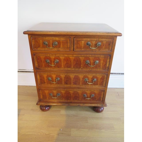 20 - A yew oyster veneer chest of small proportions with two short over three long drawers on turned feet... 