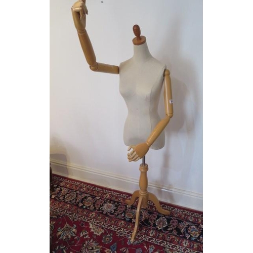 24 - A calico covered ladies tailors bust on turned tripod base, adjustable stem and articulated wooden a... 