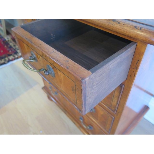 29 - A yew oyster veneer chest of small proportions with two short over three long drawers on turned feet... 