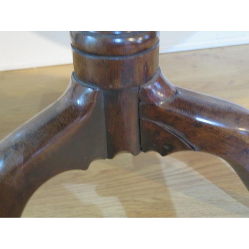 56 - A Georgian mahogany tripod table with a single piece top on a wrythern turned column and splayed fee... 