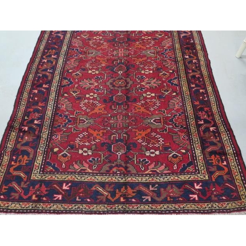 214 - A hand knotted woollen Heriz rug, 2.8m x 1.58m