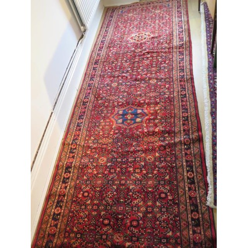221 - A hand knotted woollen Hamadam rug, 4.10m x 1.10m