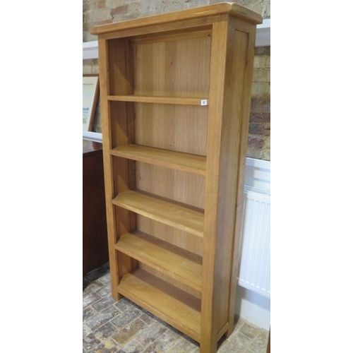 27 - A modern oak bookcase with four fixed shelves, 180cm tall x 90cm x 30cm