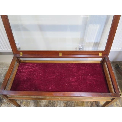 69 - A mahogany bijouterie display table on square tapering legs with bevel edge glass to the hinged top,... 