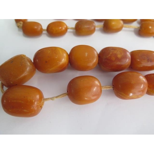498 - A string of butterscotch amber beads, largest bead approx 25mm x 20mm, total weight approx 115 grams