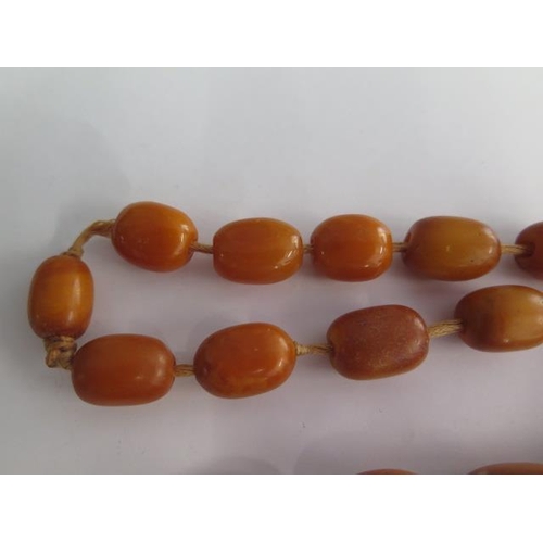 498 - A string of butterscotch amber beads, largest bead approx 25mm x 20mm, total weight approx 115 grams