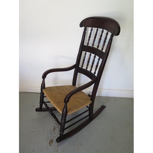 74 - An early 19th century rush seated and spindle back rocking chair, 112cm tall