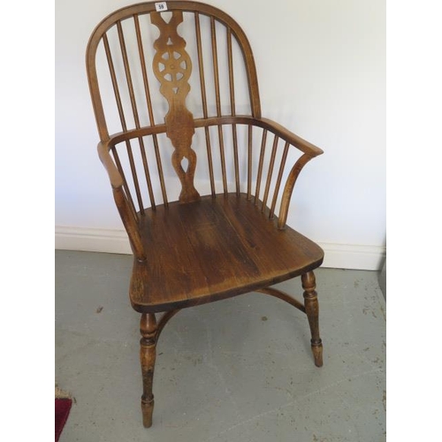 59 - A 20th century ash and beech wheel back elbow chair with a crinolene stretcher, 101cm tall x 53cm wi... 