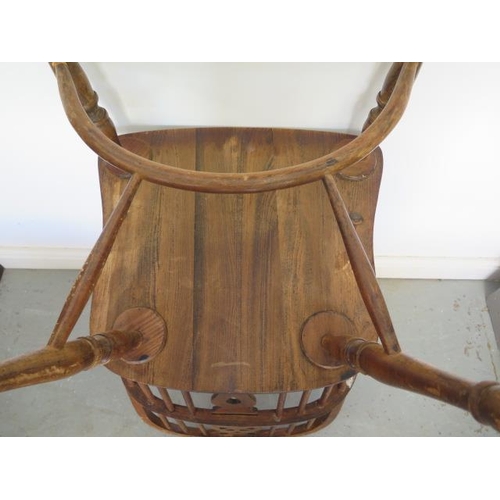 59 - A 20th century ash and beech wheel back elbow chair with a crinolene stretcher, 101cm tall x 53cm wi... 